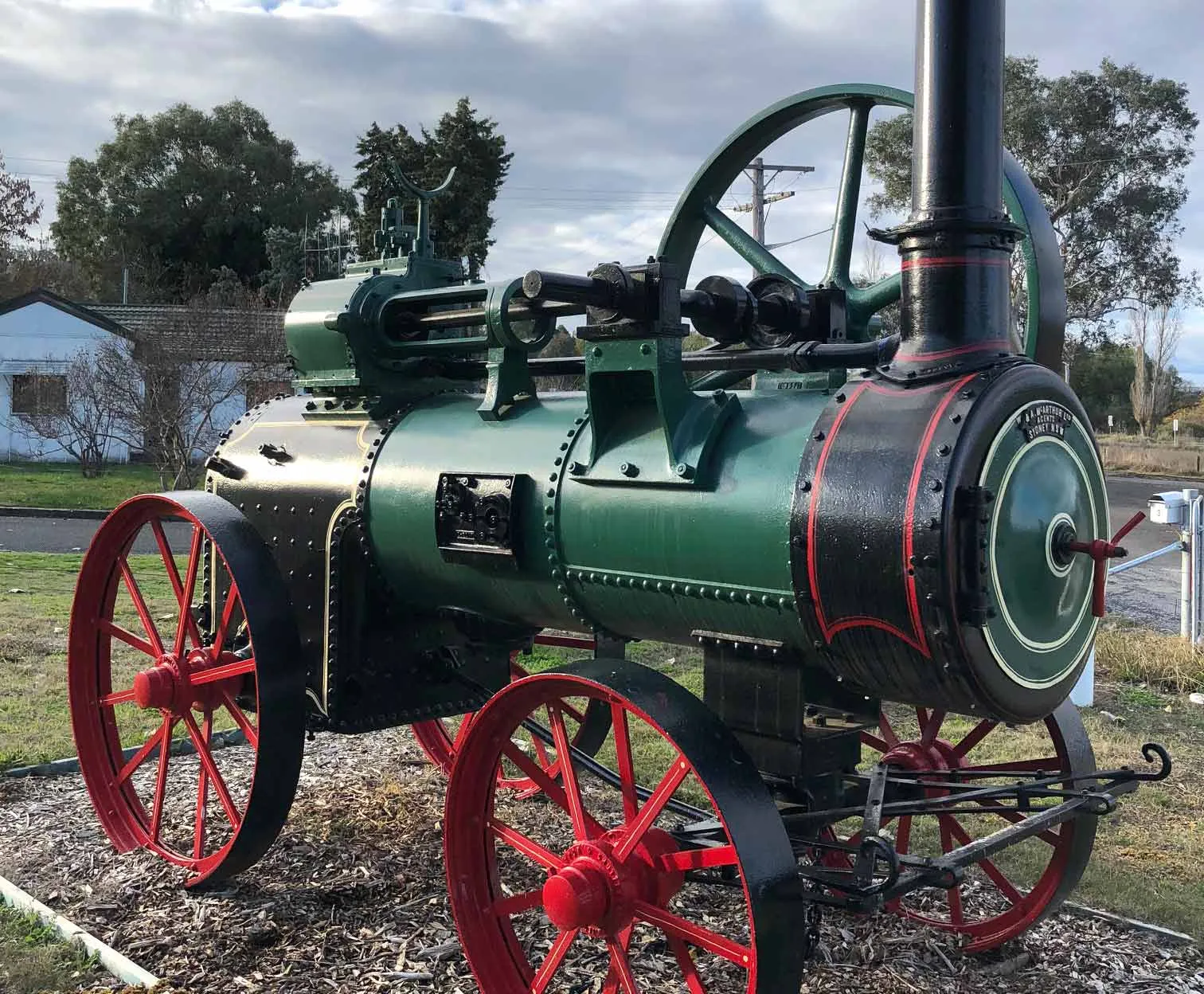 A restored green and red Clayton & Shuttleworth portable steam engine on display outdoors.